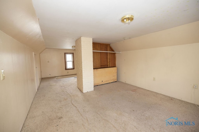 additional living space with light carpet and vaulted ceiling