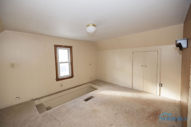 carpeted spare room with lofted ceiling