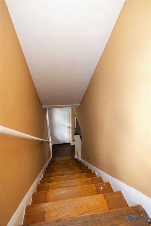 staircase with hardwood / wood-style flooring and vaulted ceiling