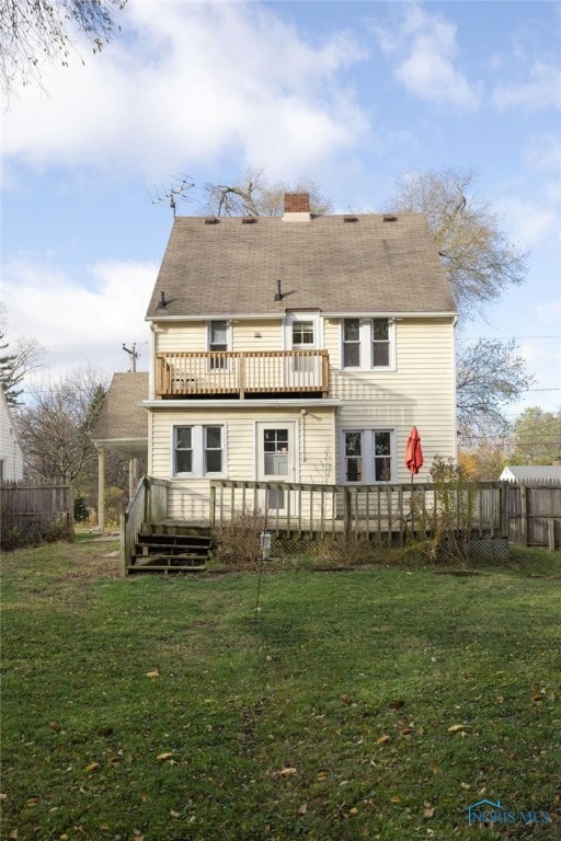 back of house featuring a yard, a balcony, and a deck