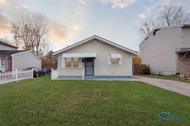 bungalow-style home with a yard