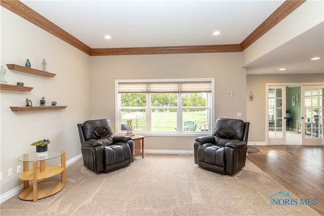 sitting room featuring wood-type flooring, a healthy amount of sunlight, and crown molding