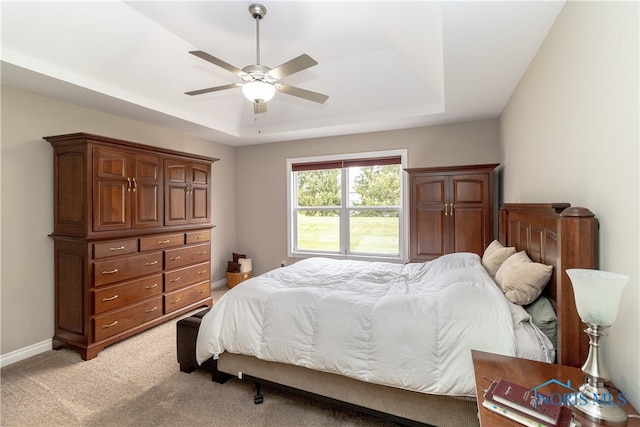 bedroom featuring ceiling fan, a raised ceiling, and carpet