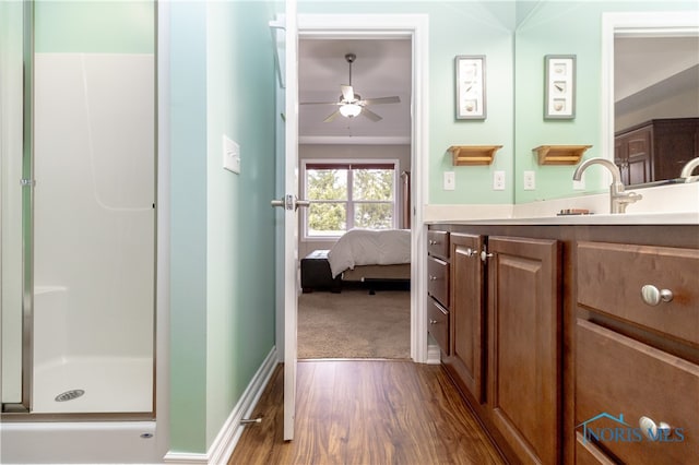 bathroom featuring wood-type flooring, ceiling fan, vanity, and a shower with shower door