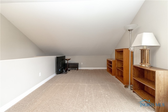 additional living space featuring lofted ceiling and carpet floors