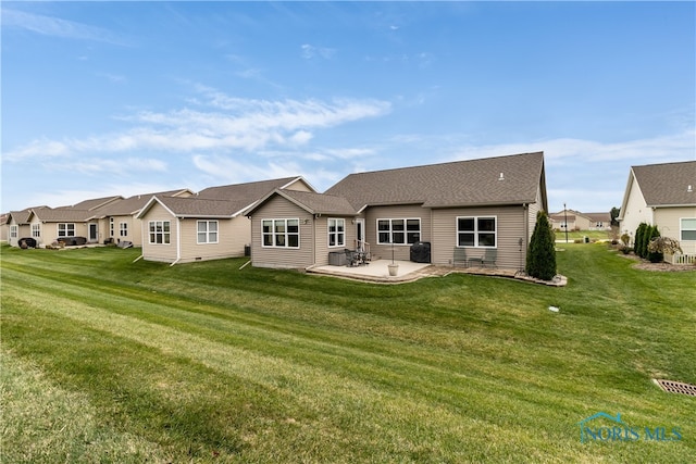 rear view of house featuring a lawn and a patio