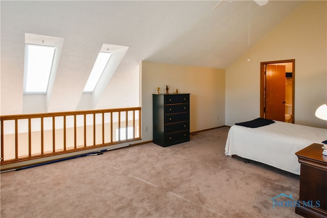 bedroom featuring carpet flooring, ensuite bath, ceiling fan, and lofted ceiling with skylight