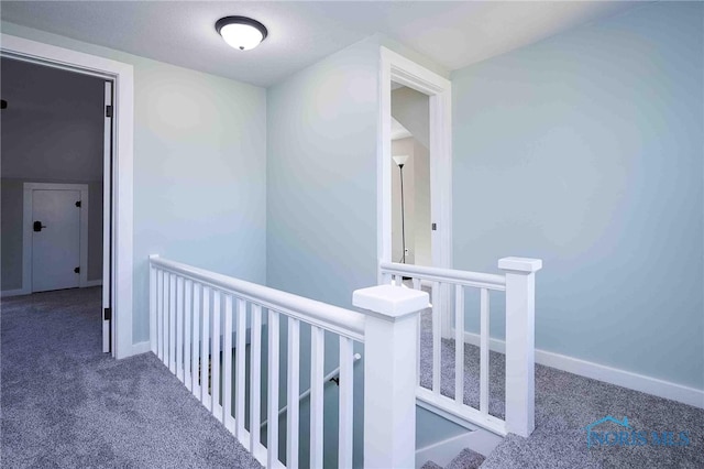 hallway featuring dark colored carpet