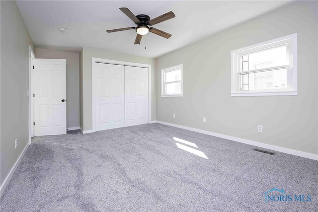 unfurnished bedroom featuring ceiling fan, a closet, and carpet floors