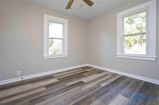 unfurnished room featuring dark wood-type flooring, a wealth of natural light, and ceiling fan