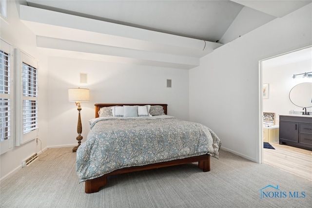 bedroom featuring connected bathroom, light colored carpet, lofted ceiling, and sink