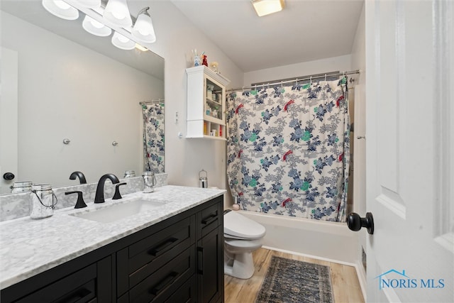 full bathroom with hardwood / wood-style floors, vanity, toilet, and shower / tub combo with curtain