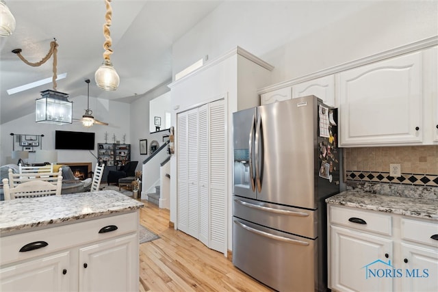 kitchen featuring pendant lighting, white cabinets, stainless steel refrigerator with ice dispenser, light hardwood / wood-style flooring, and ceiling fan