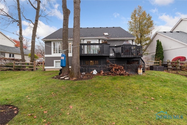 rear view of house with a yard and a wooden deck