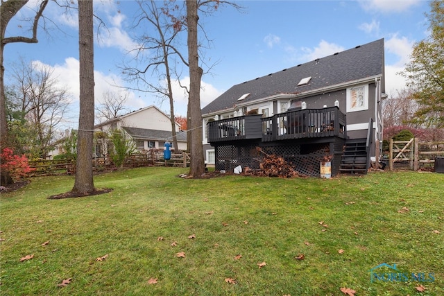 rear view of house with a lawn and a deck