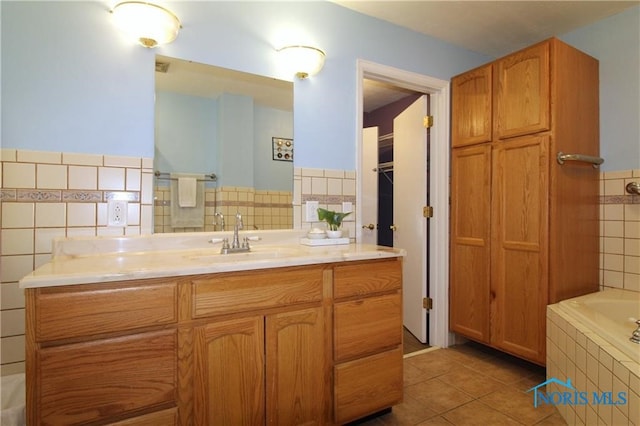 bathroom with a washtub, vanity, and tile patterned floors