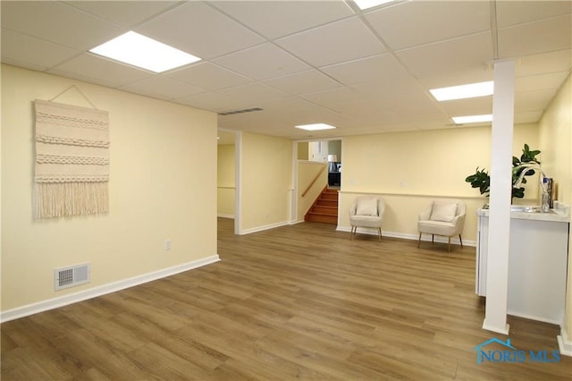 basement featuring sink, a paneled ceiling, and hardwood / wood-style floors