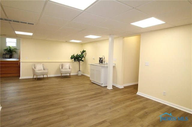 unfurnished room featuring hardwood / wood-style flooring and a drop ceiling