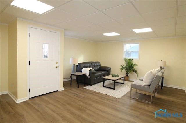 living room with a paneled ceiling, wood-type flooring, and crown molding