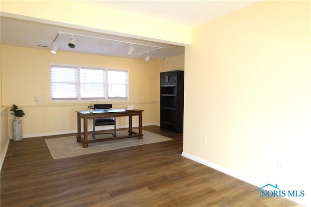 dining space with dark wood-type flooring and rail lighting