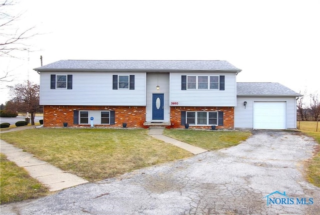 raised ranch featuring a garage and a front yard