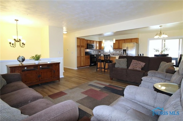 living room featuring dark hardwood / wood-style flooring, sink, and an inviting chandelier