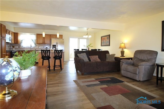 living room with sink, dark hardwood / wood-style flooring, and a notable chandelier