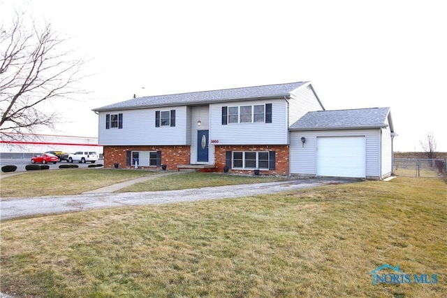 raised ranch with a front lawn and a garage