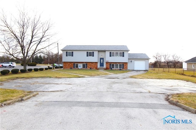 split foyer home featuring a garage and a front yard