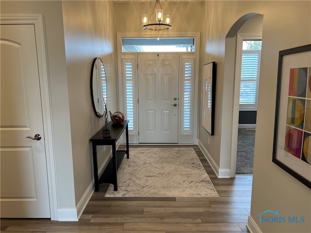 foyer featuring dark wood-type flooring and a chandelier