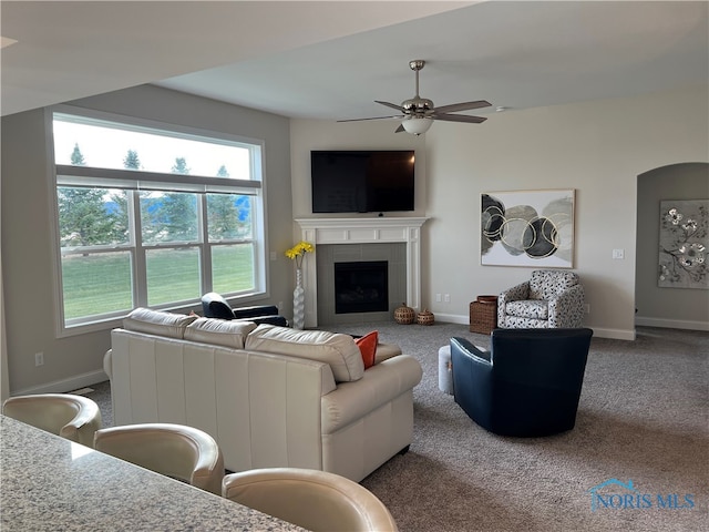 living room with carpet, a fireplace, and ceiling fan