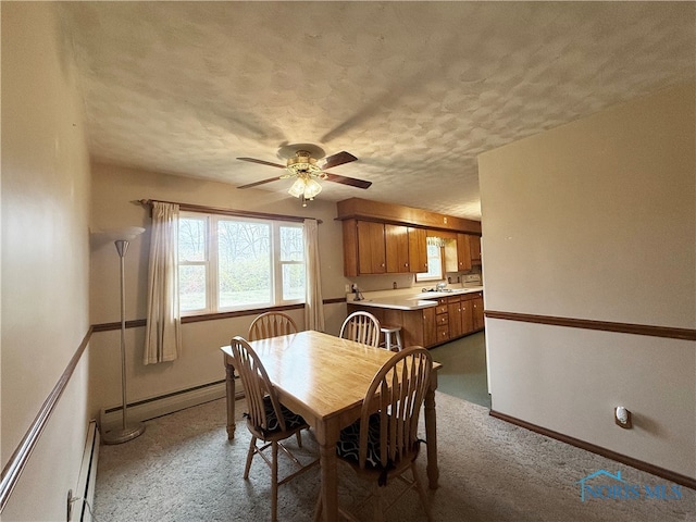 dining room featuring carpet, a textured ceiling, baseboard heating, and ceiling fan