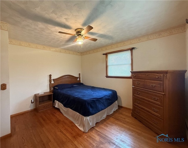 bedroom with ceiling fan and light hardwood / wood-style floors