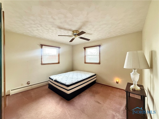 bedroom with multiple windows, ceiling fan, carpet, and a baseboard radiator