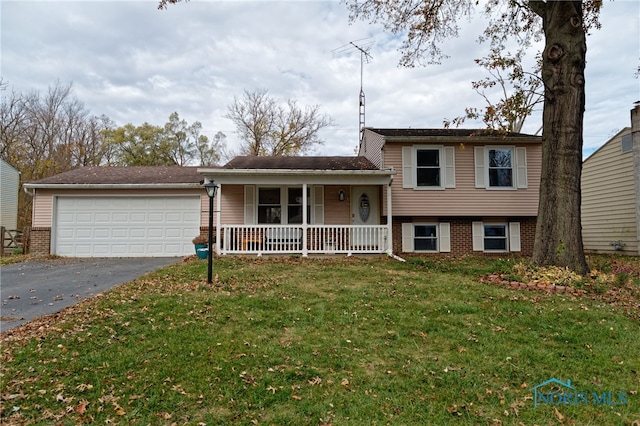 split level home featuring a front yard, a garage, and covered porch