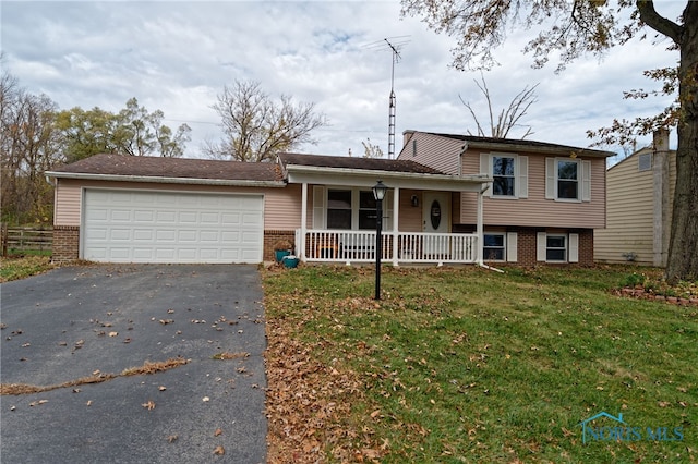 split level home with a porch, a garage, and a front yard