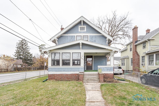 view of front of house featuring a front lawn and covered porch