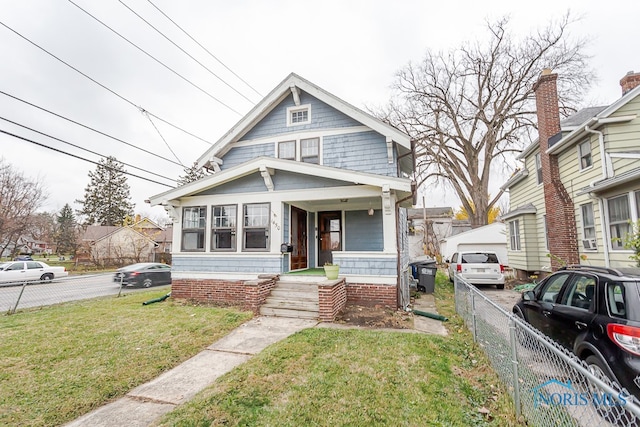 bungalow with covered porch and a front yard