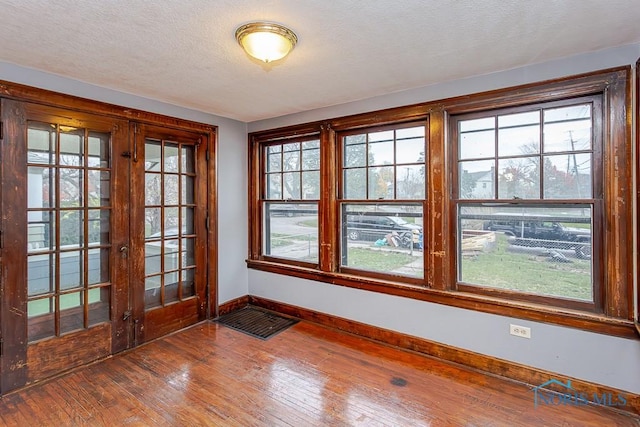 doorway featuring french doors, a textured ceiling, and hardwood / wood-style flooring