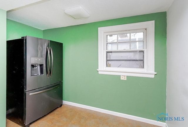 kitchen featuring stainless steel fridge and light tile patterned flooring