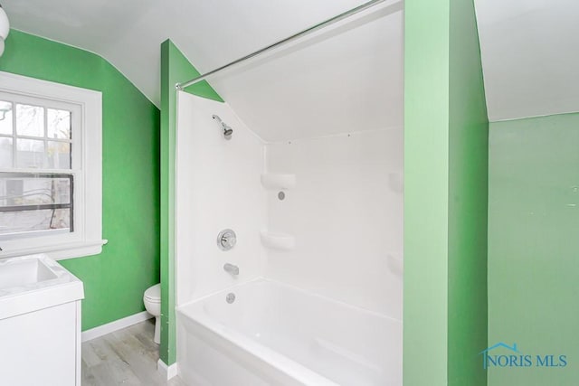 full bathroom with vanity, lofted ceiling, shower / tub combination, toilet, and wood-type flooring