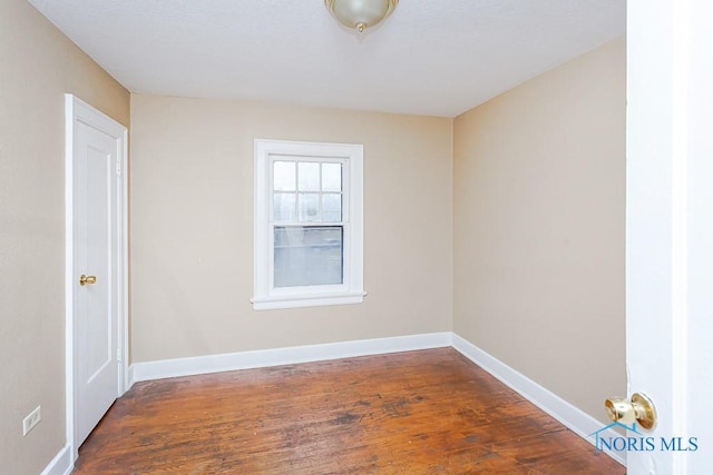 spare room featuring dark wood-type flooring