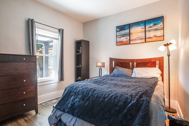 bedroom with light wood-type flooring and multiple windows