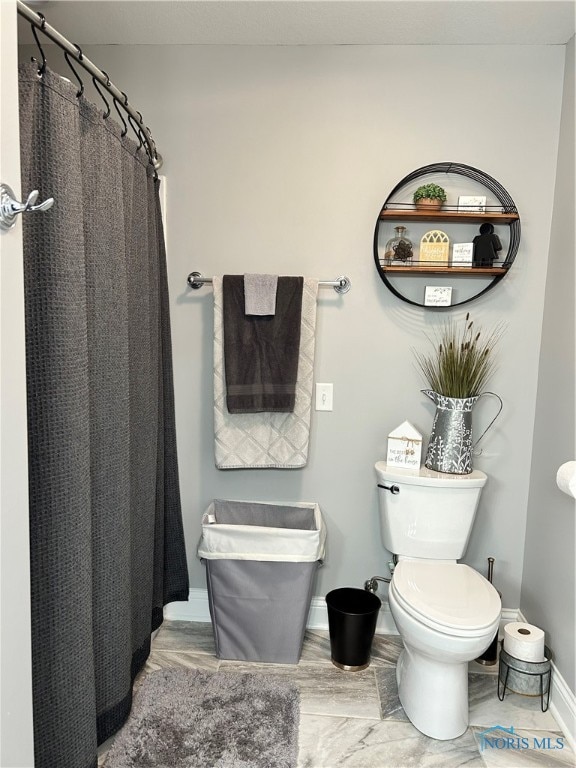 bathroom featuring toilet and walk in shower