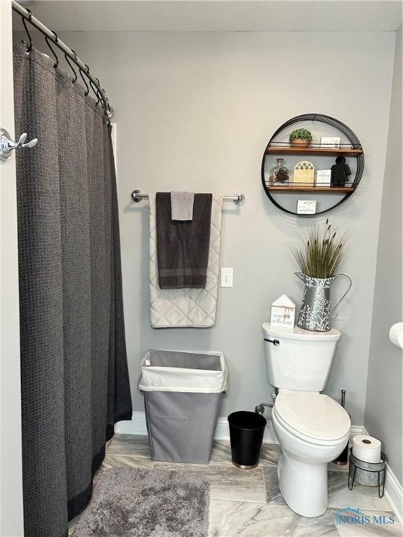 bathroom with a shower with curtain and toilet