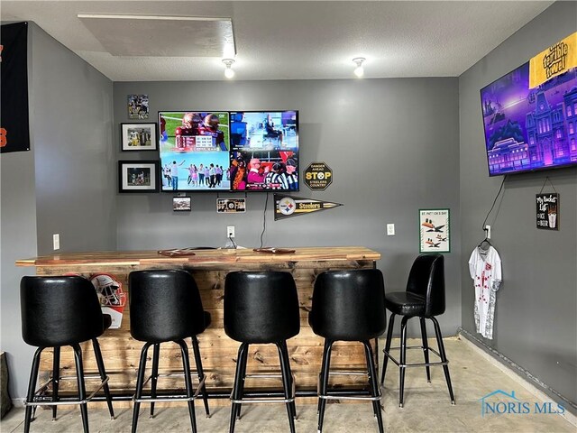 bar featuring a textured ceiling