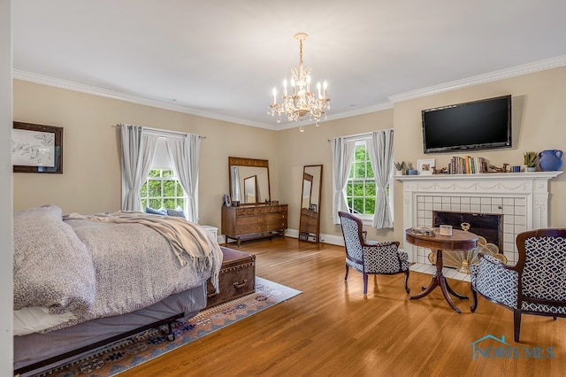 bedroom featuring multiple windows, hardwood / wood-style floors, and a fireplace