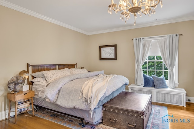 bedroom featuring radiator, wood-type flooring, a chandelier, and crown molding