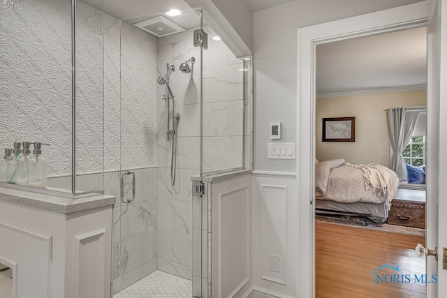 bathroom featuring hardwood / wood-style floors, a shower with door, and ornamental molding