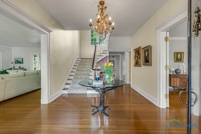 entrance foyer featuring a wealth of natural light, wood-type flooring, and a chandelier